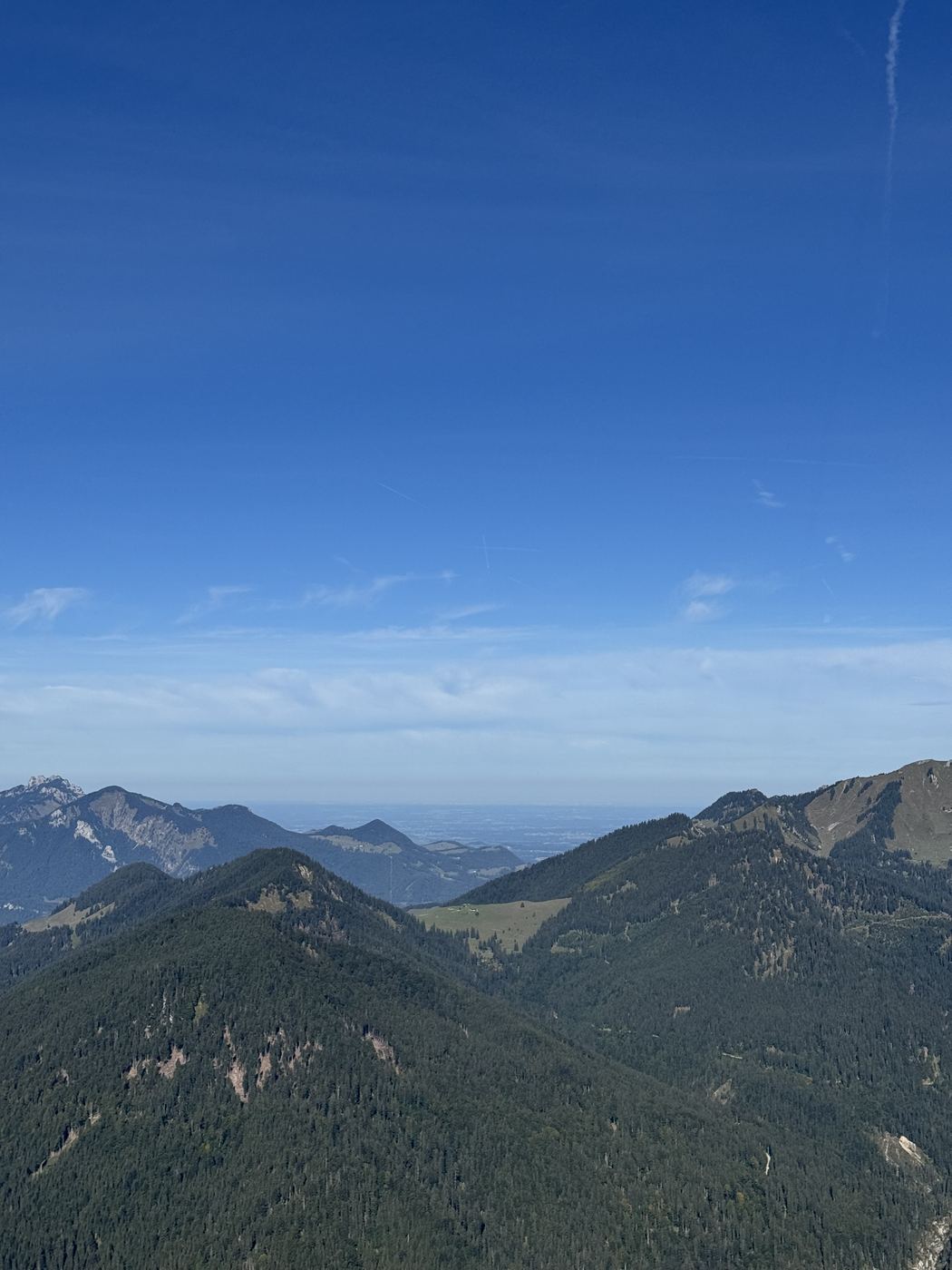 Blick vom ersten Gipfel über gestaffelte Bergrücken bis ins flache Vorland.